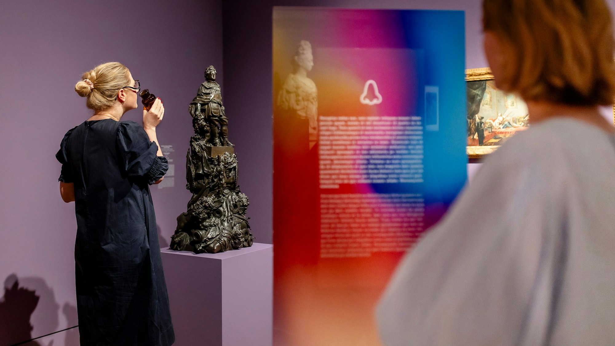 Eine Frau riecht an etwas bei der Ausstellung "Die geheime Macht der Düfte" im Kunstpalast.