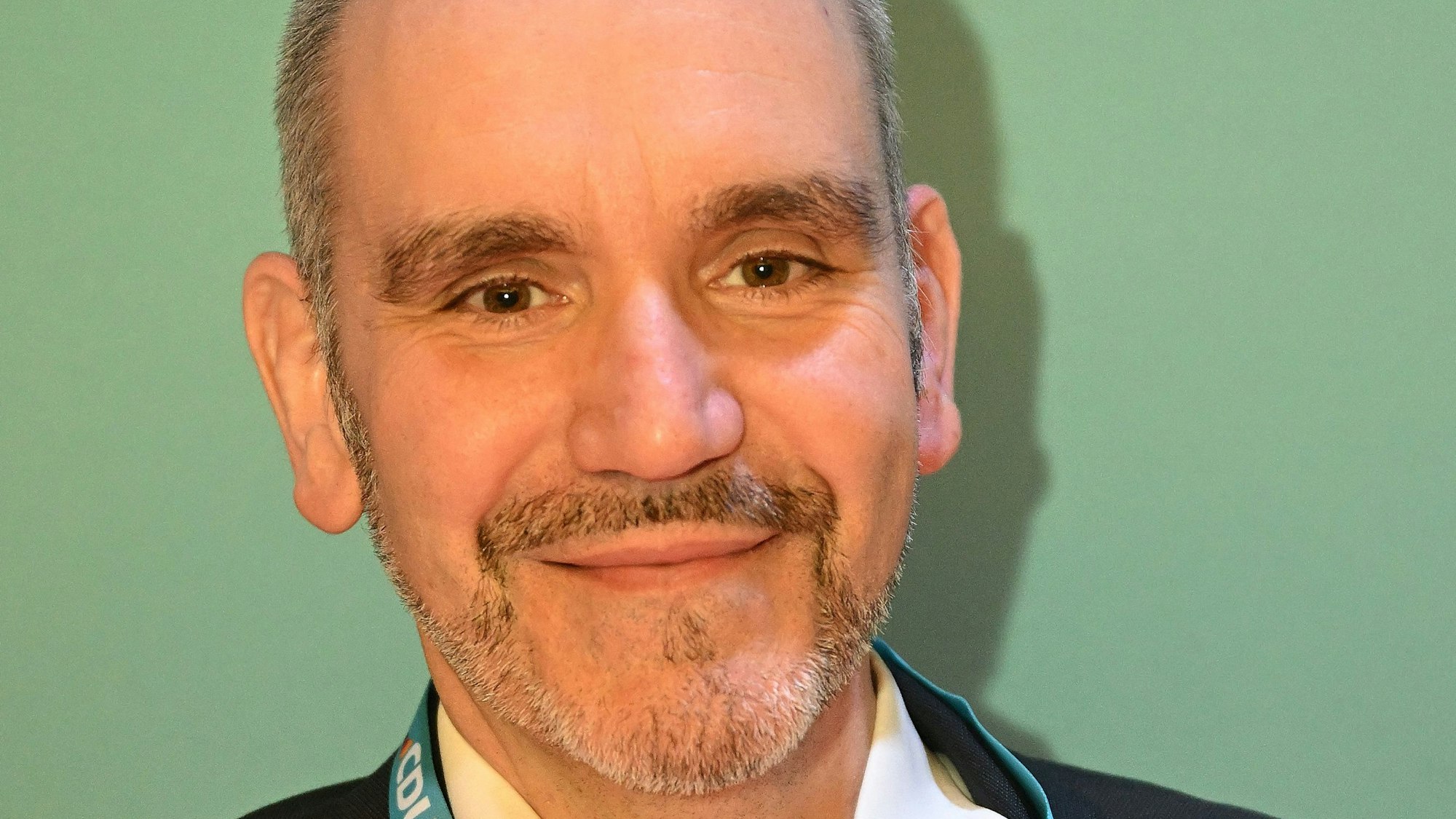 Ein Mann mittleren Alters lächelt in die Kamera.