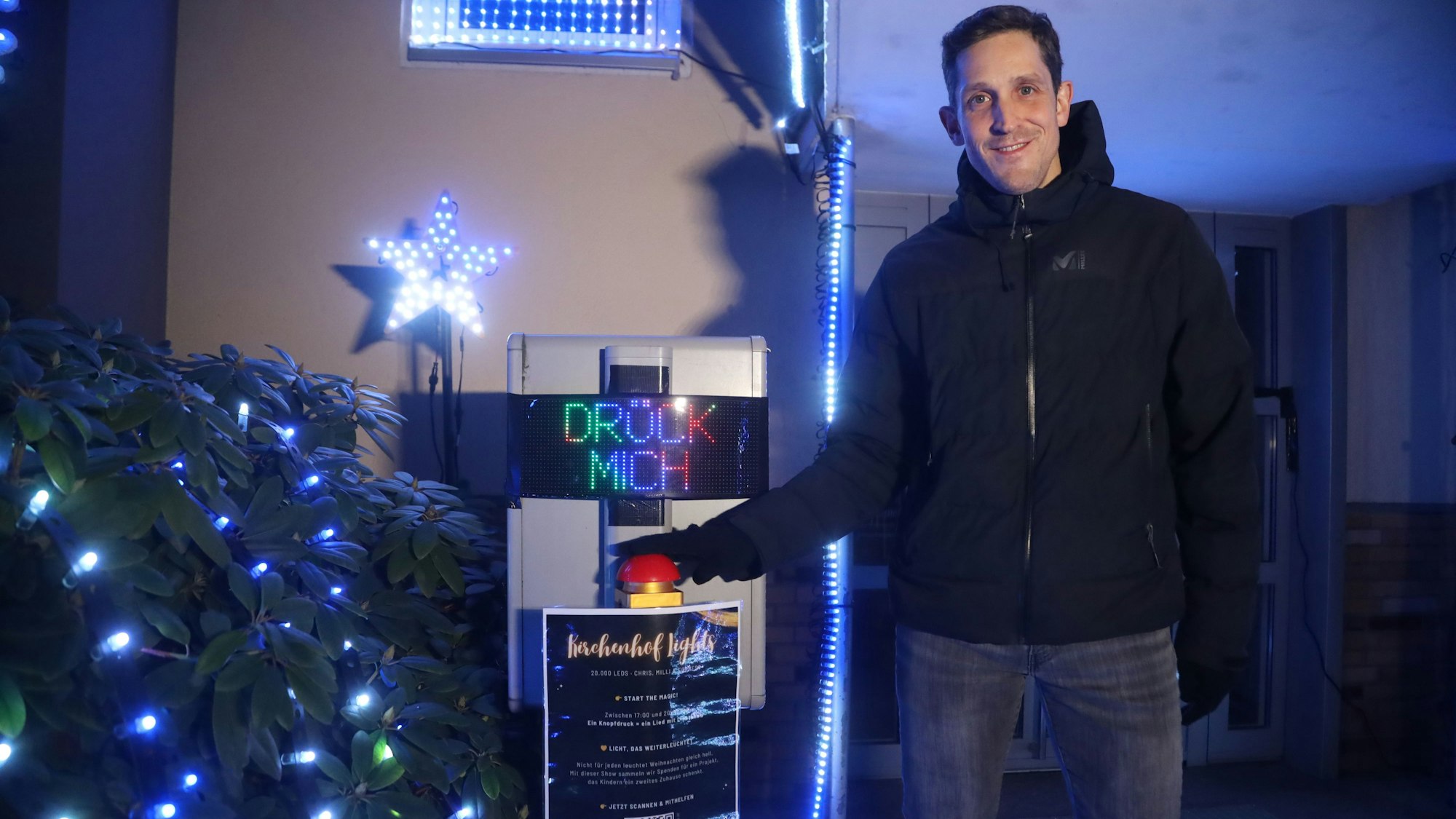 Hier zeigt Simon Biela den Buzzer, mit dem die Lichtshow am Weihnachtshaus startet.