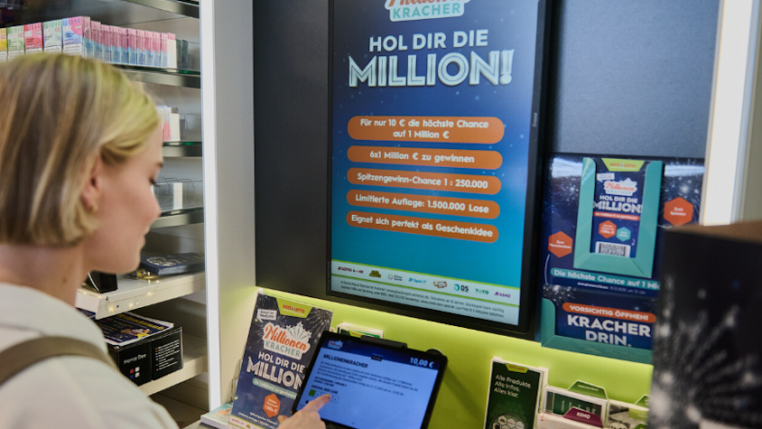Eine Frau steht in einem Lottogeschäft, um bei der Lotterie MillionenKracher mitzumachen