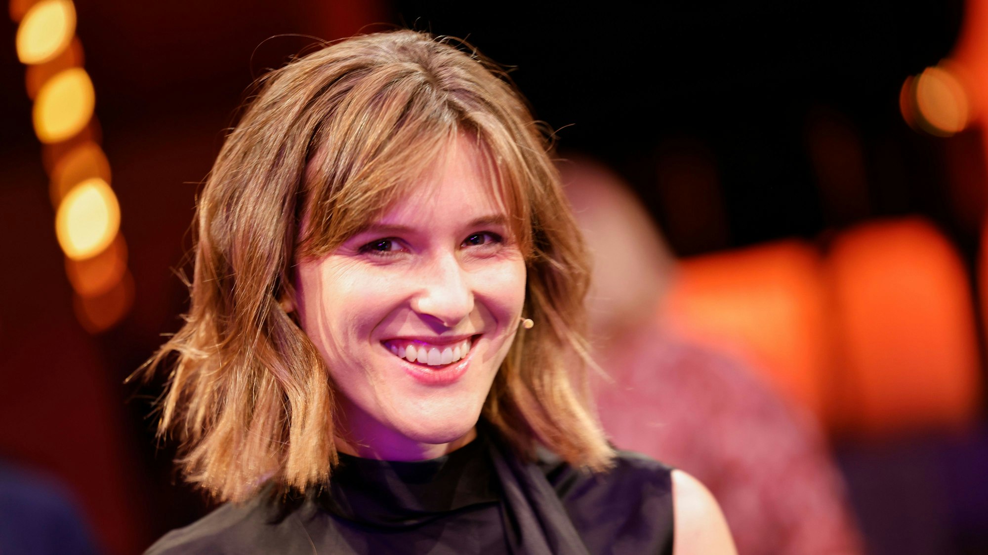 Eine Frau lächelt bei einer Preisverleihung in die Kamera.