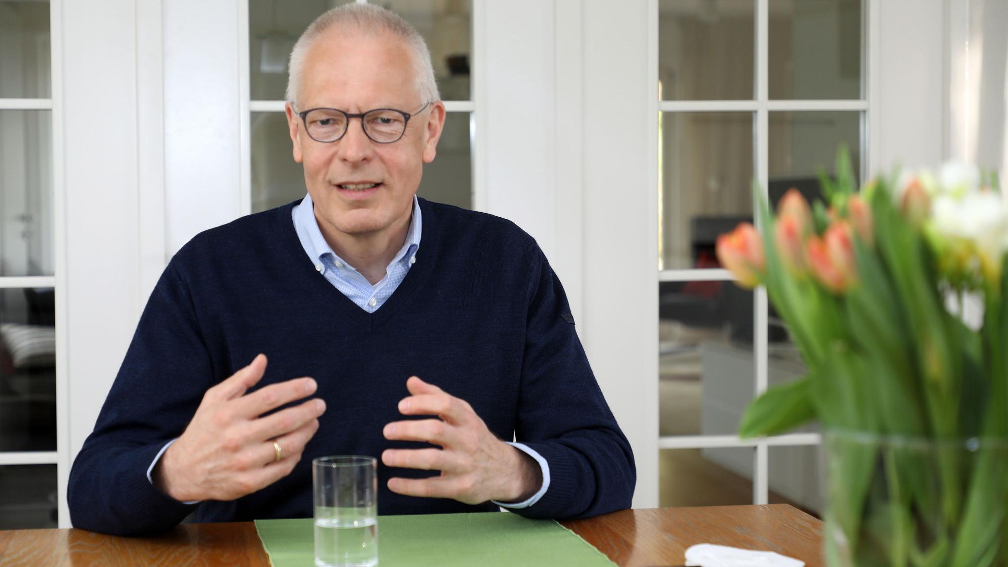 Dr. Hermann-Josef Tebroke sitzt an einem Tisch in seinem Privathaus in Lindlar.