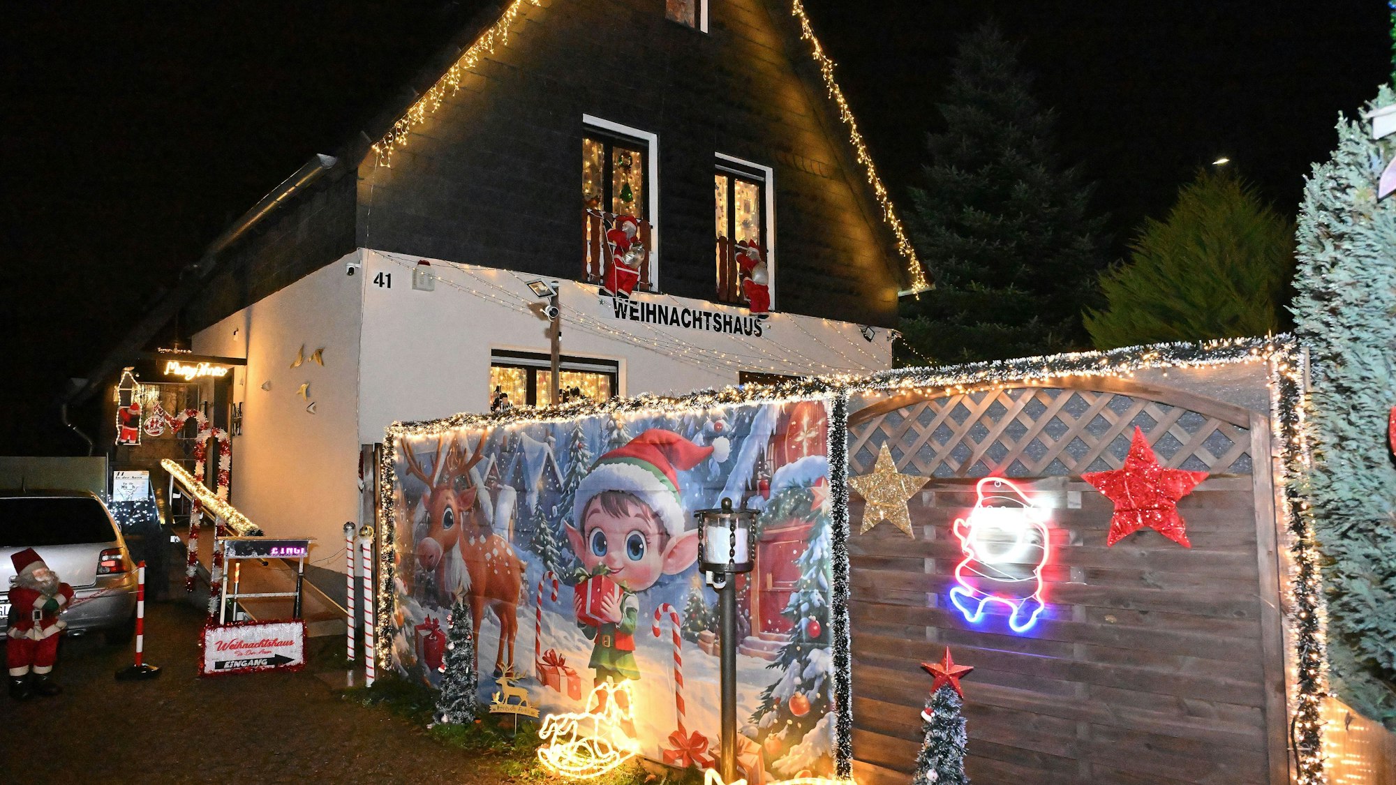 Das Weihnachtshaus und der dazugehörige Zaun sing mit Lichtern, Sternen und einer weihnachtlich bedruckten Decke geschmückt.