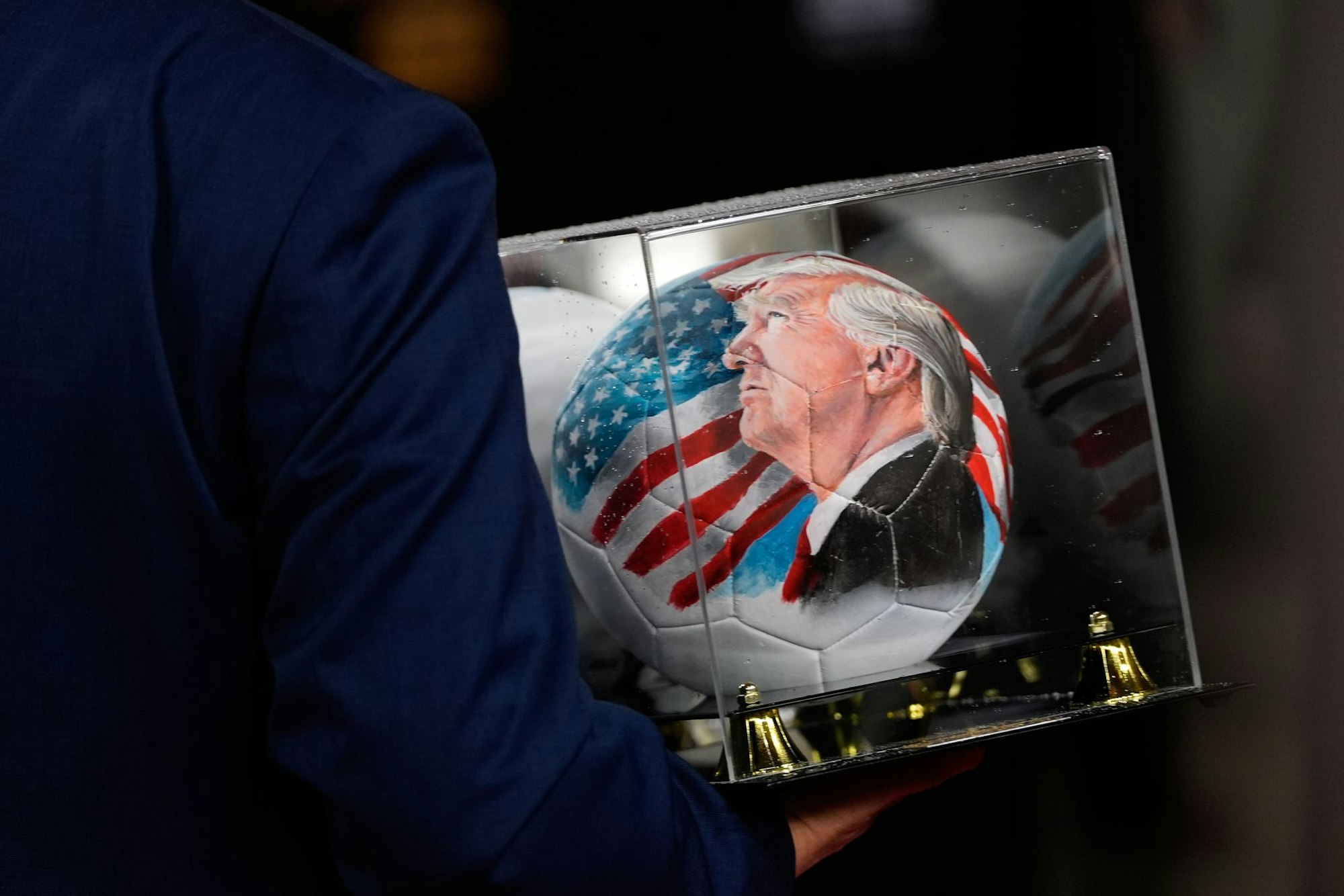 Vor der Auslosung ist auch ein Ball mit dem Gesicht von Trump zu sehen.