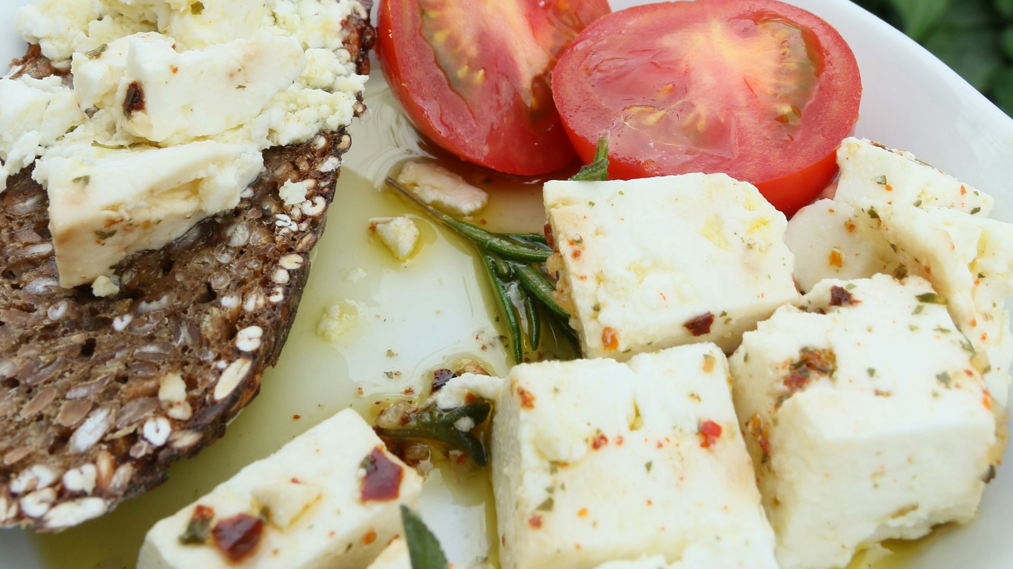 Das Bild zeigt Käse vom Ziegenhof Zickzack in Kirchheim – arrangiert mit einem Brot und Tomate.