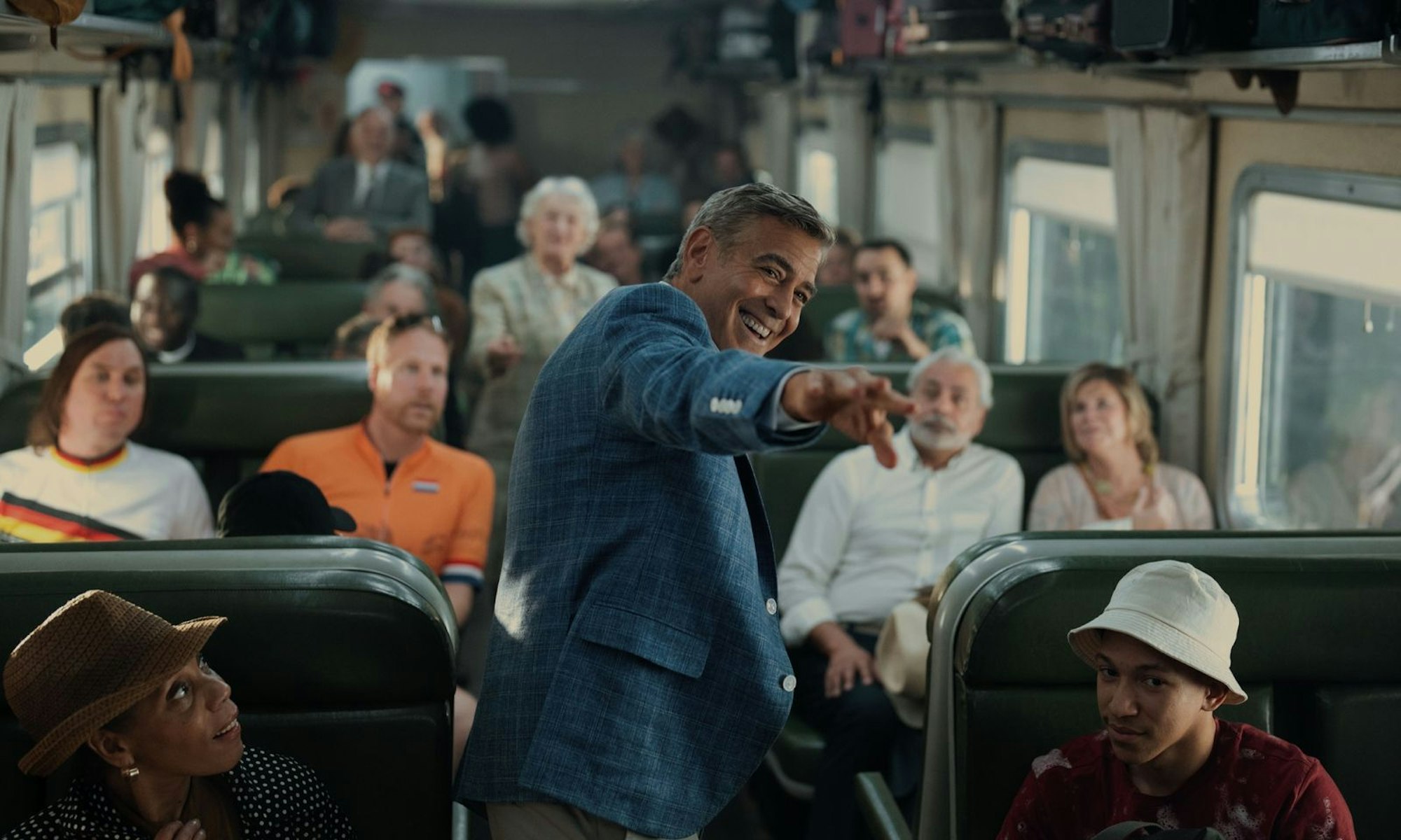 Jay Kelly (George Clooney) fährt mit der Bahn durch Europa und lässt sich vergöttern - unter anderem von Lars Eidinger (links am Fenster). (Bild: 2025 Netflix / Peter Mountain)