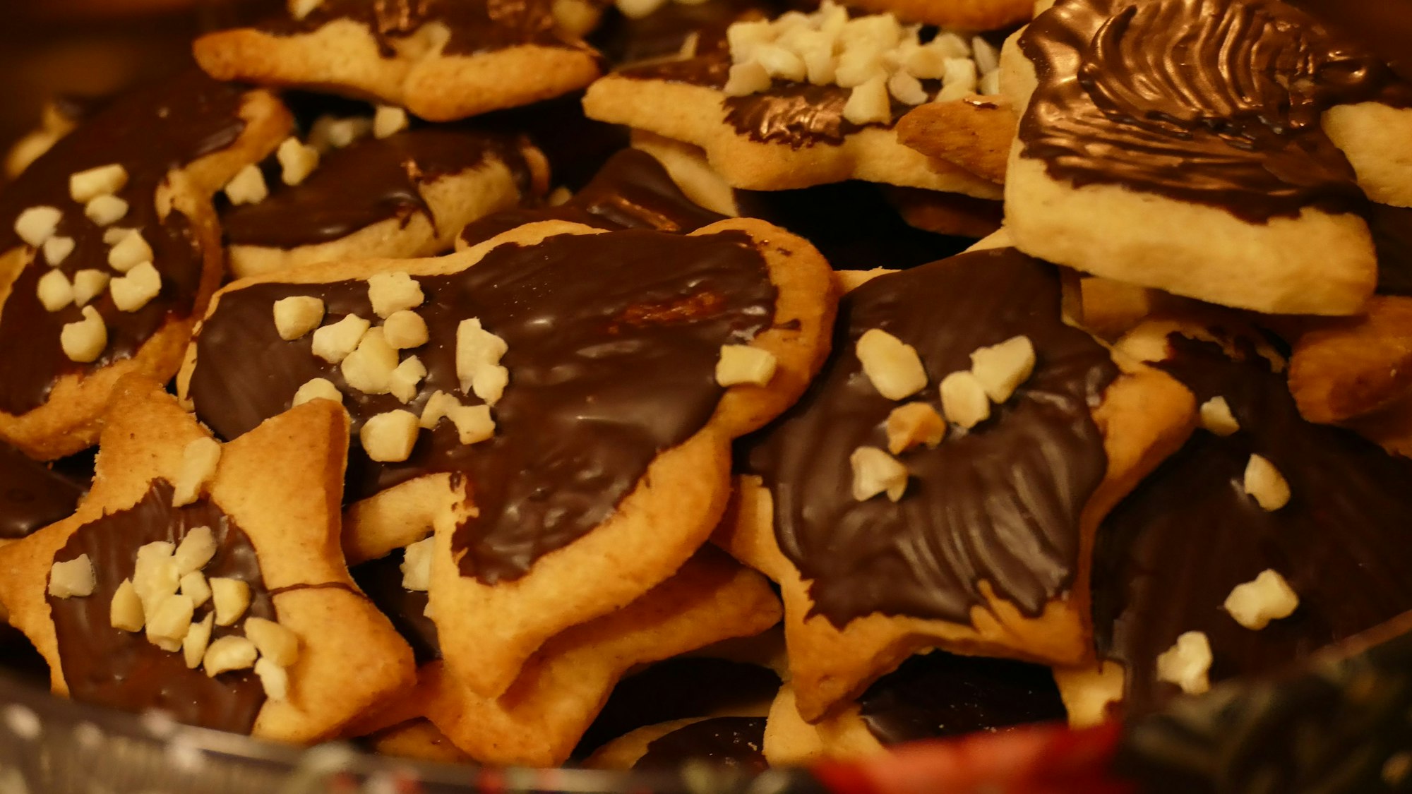 Die fertigen Mürbeteig-Plätzchen können mit Nüssen und Schokolade verziert werden.