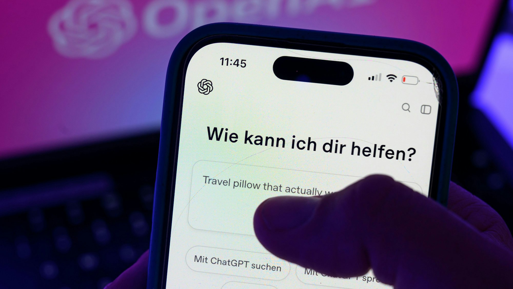 Ein Smartphone mit dem KI-Chatbot ChatGPT ist vor dem Logo des US-Softwareunternehmens OpenAI zu sehen.