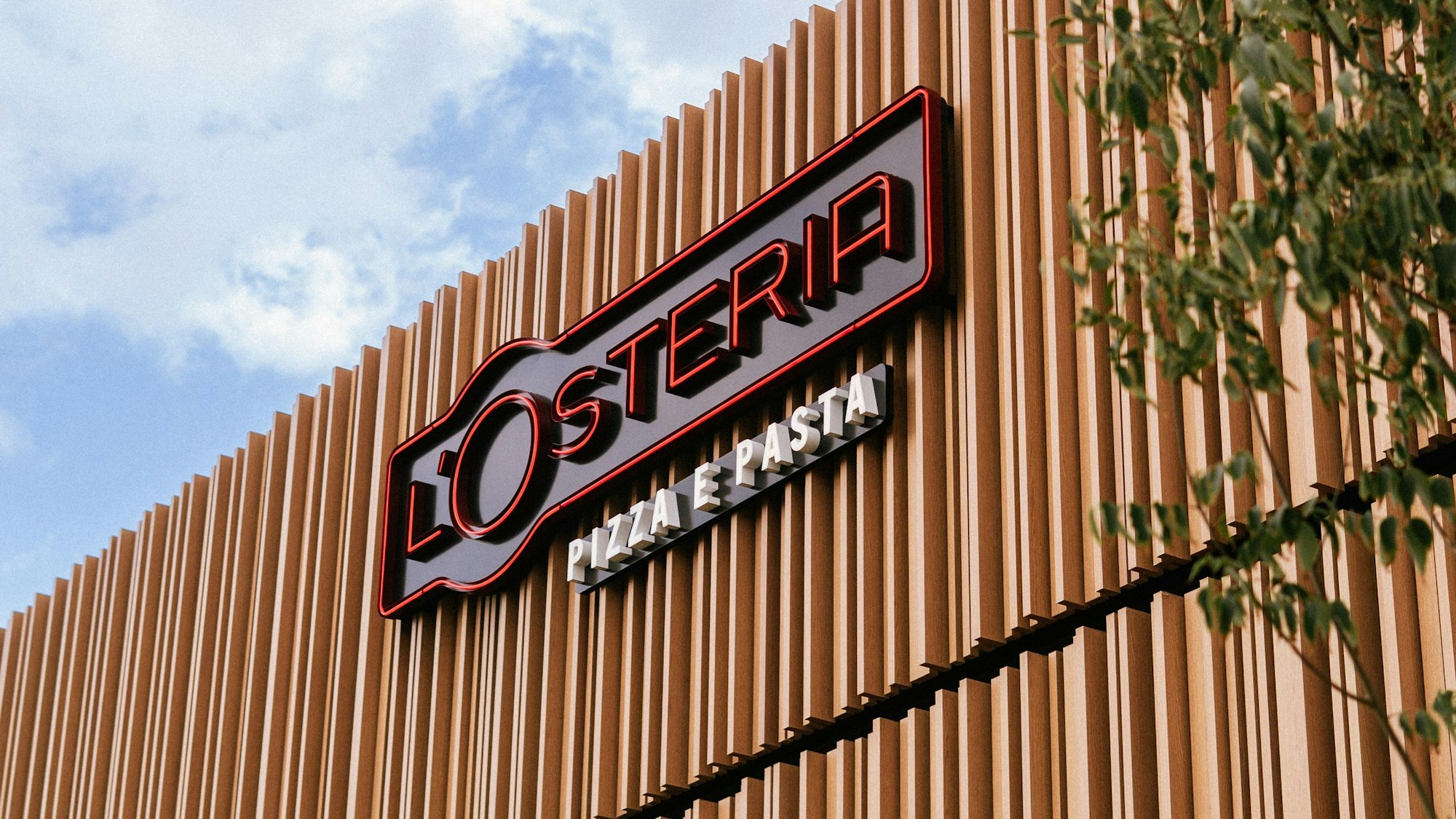 Das Foto zeigt den Schriftzug L’Osteria „Pizza e Pasta“ auf einer Hausfassade.