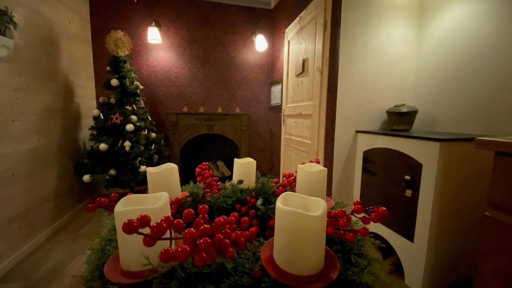 Zu sehen ist ein Zimmer mit Adventskranz und Tannenbaum.
