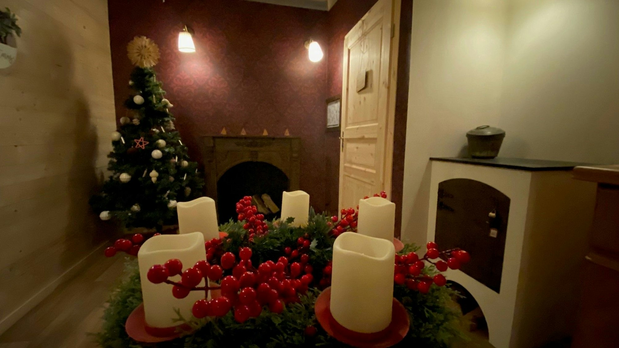 Zu sehen ist ein Zimmer mit Adventskranz und Tannenbaum.