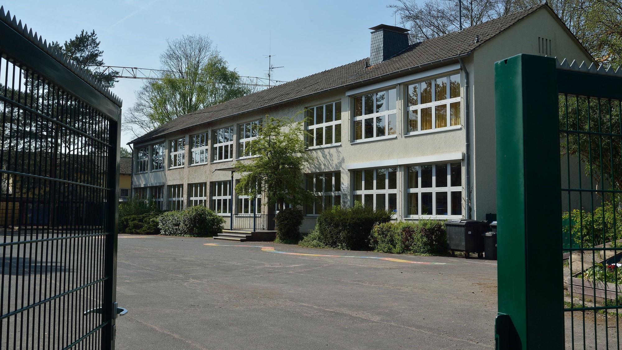 Das Schultor steht offen. Der Blick fällt auf das Hauptgebäude.