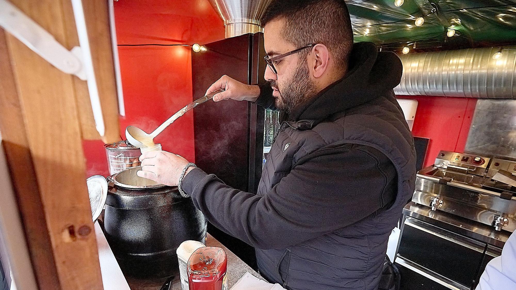 Abbas Kteich steht in einer Imbissbude auf dem Weihnachtsmarkt in Monschau. Er füllt Suppe in ein kleines Gefäß, die später im Labor untersucht wird.