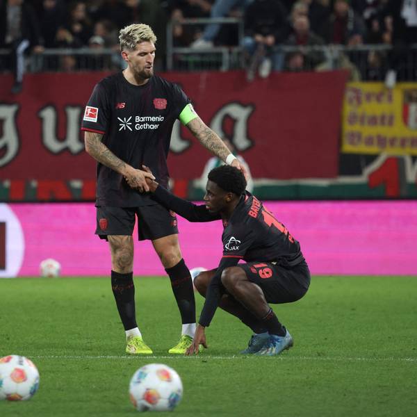 Bayer Leverkusen's German midfielder #08 Robert Andrich (L) helps up deceived Bayer Leverkusen's Dutch forward #19 Ernest Poku after the end of the German first division Bundesliga football match between FC Augsburg and Bayer Leverkusen in Augsburg, southern Germany, on December 6, 2025. (Photo by Karl-Josef HILDENBRAND / AFP) / DFL REGULATIONS PROHIBIT ANY USE OF PHOTOGRAPHS AS IMAGE SEQUENCES AND/OR QUASI-VIDEO