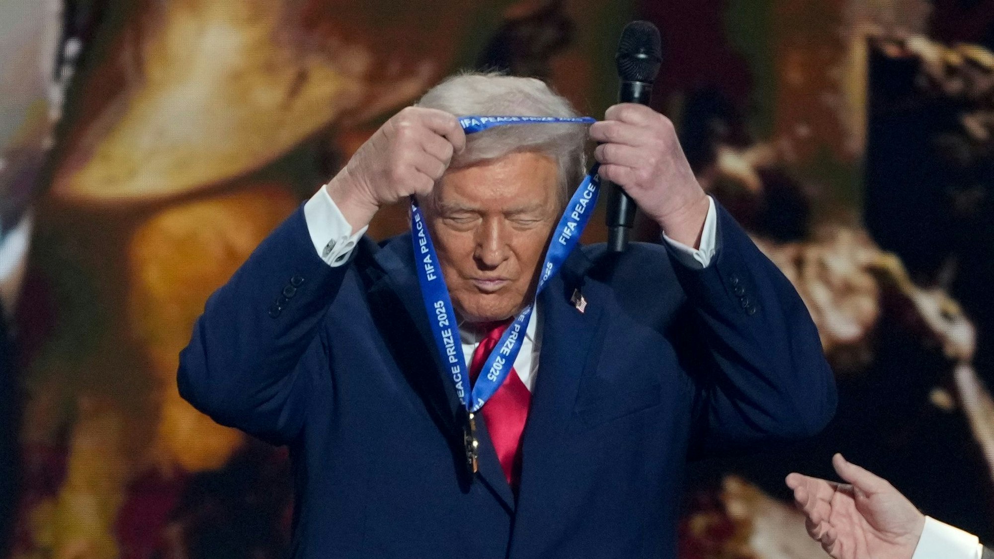 US-Präsident Trump hängt sich die FIFA-Medaille selber um.