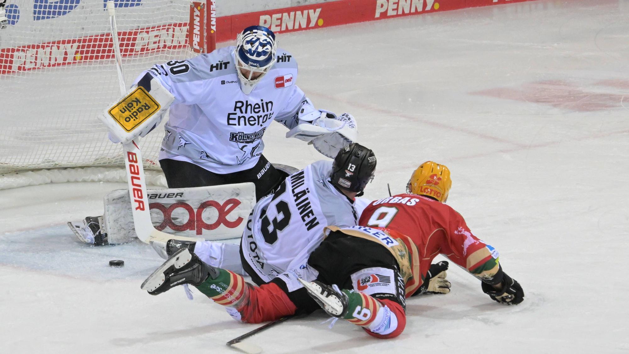 Hai Valtteri Kemiläinen und Jan Urbas von den Fischtown Pinguins vor KEC-Goalie Janne Juvoven