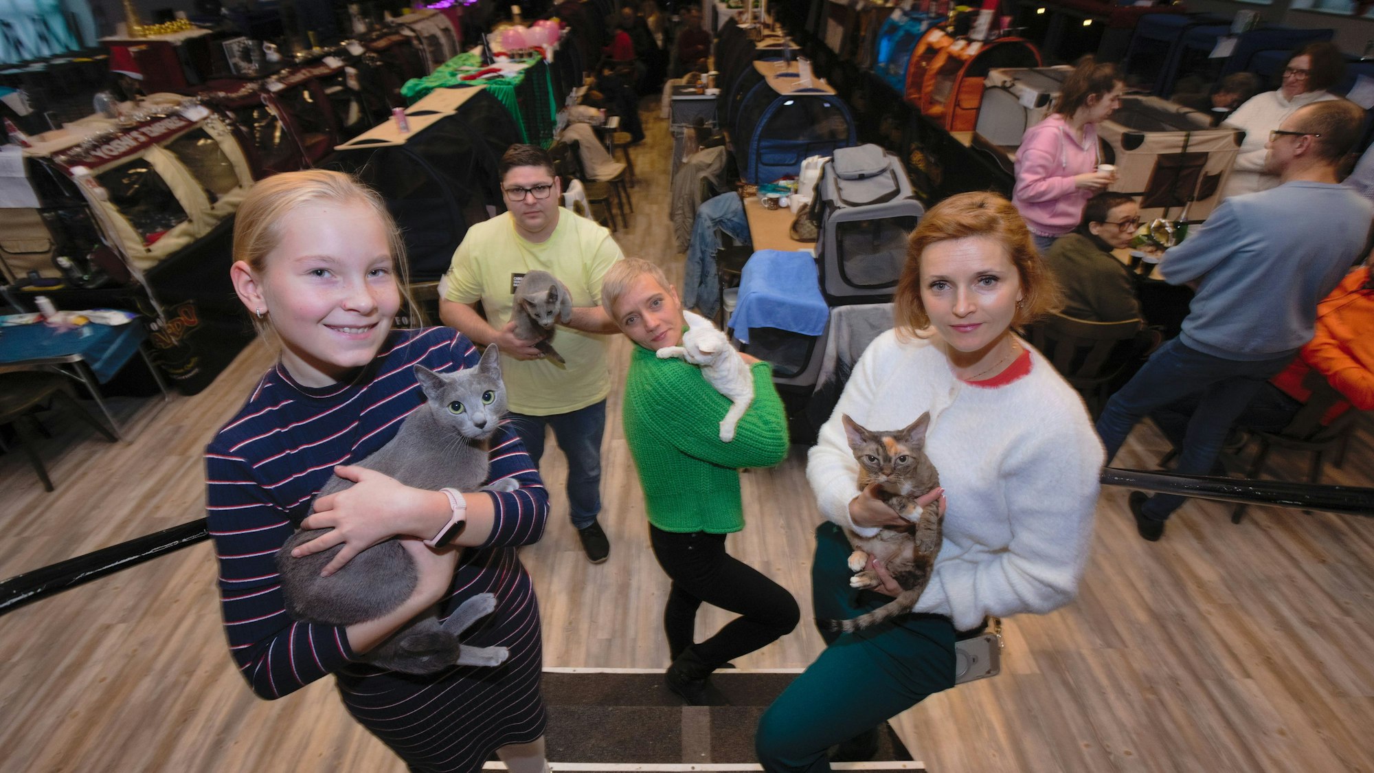 Vier Personen halten ihre Katzen im Arm.
