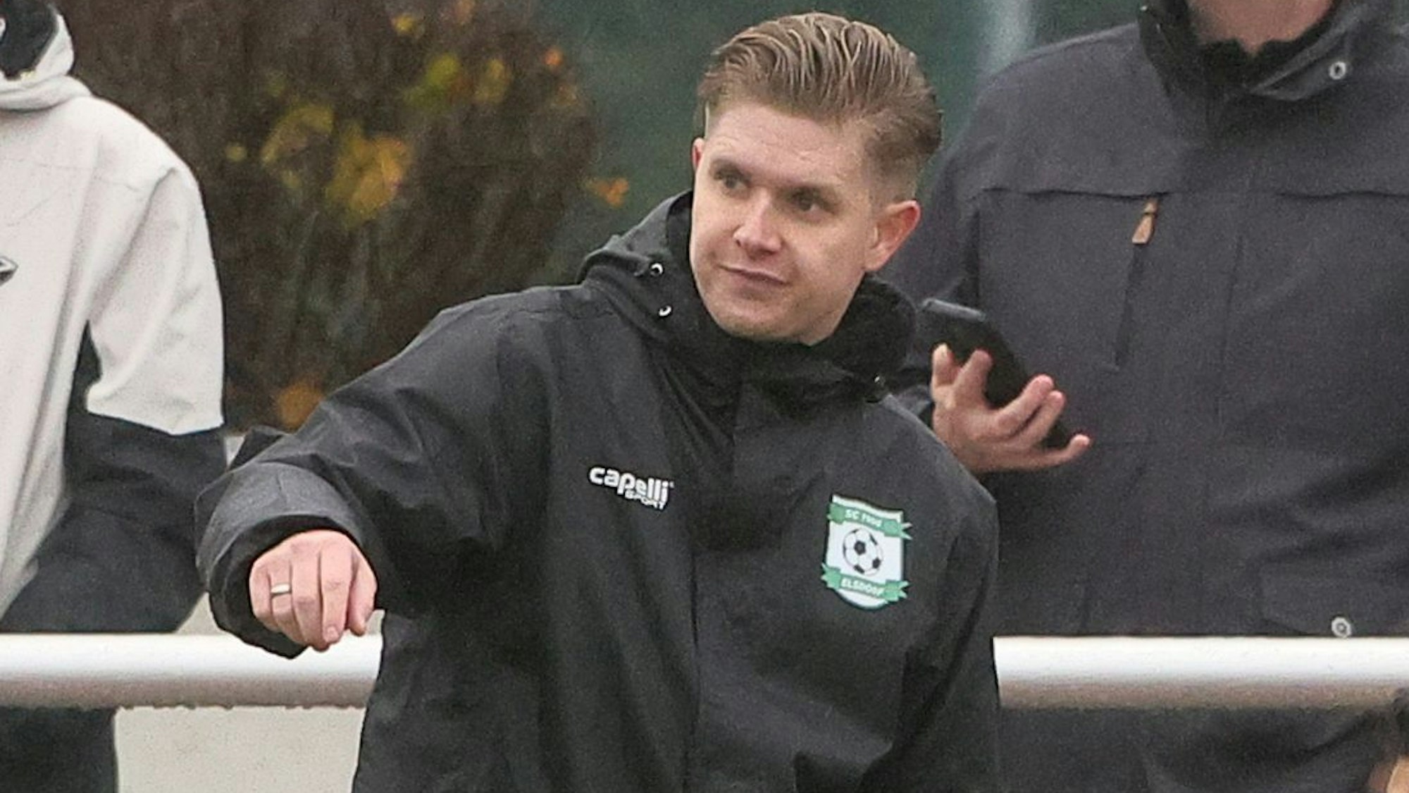 Das Foto zeigt den Elsdorfer Trainer, der warnend den Arm ausstreckt.
