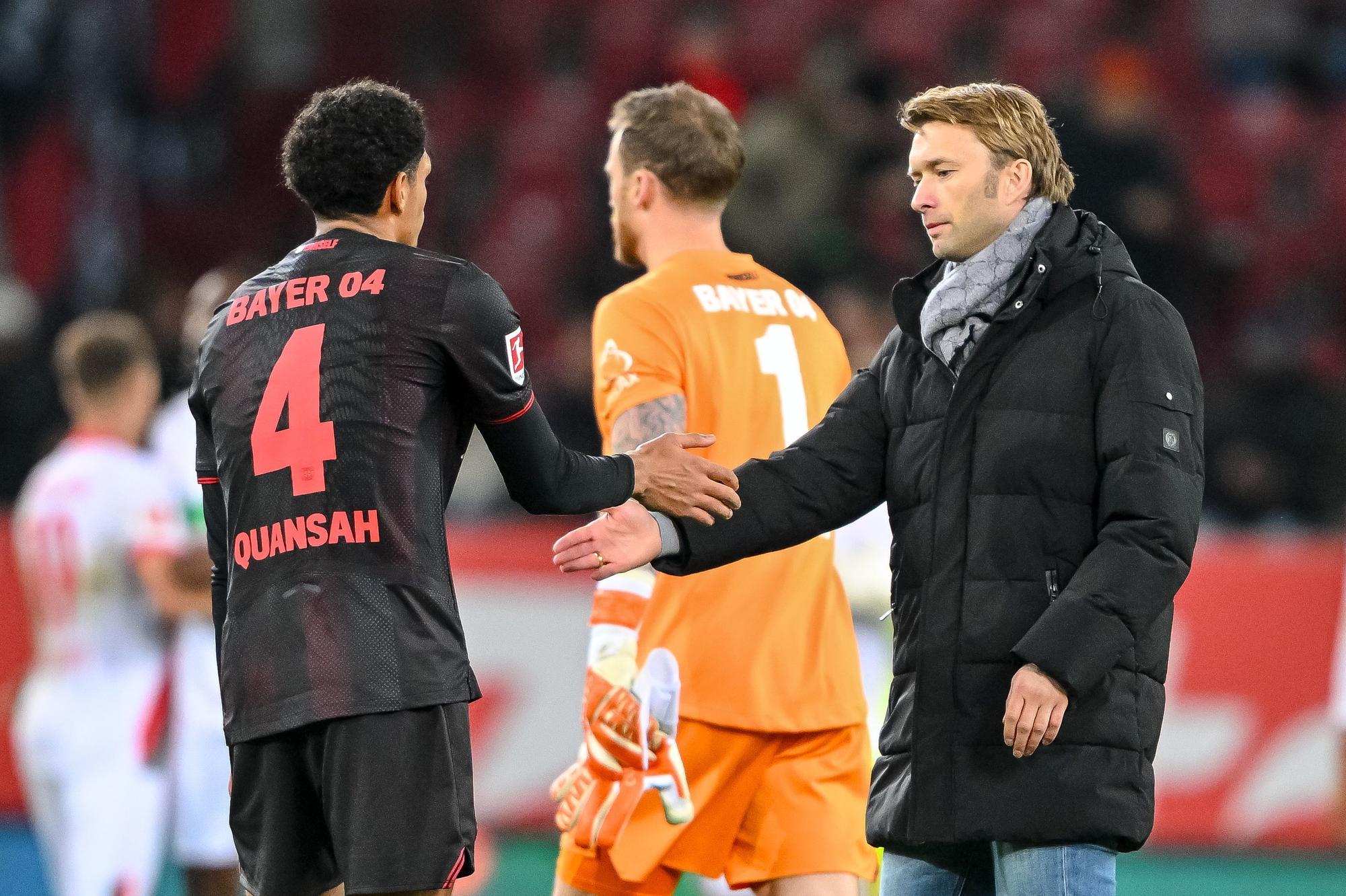 06.12.2025, Bayern, Augsburg: Fußball: Bundesliga, FC Augsburg - Bayer Leverkusen, 13. Spieltag, WWK-Arena. Jarell Quansah (l, Bayer Leverkusen), Torwart Mark Flekken (Bayer Leverkusen) und Geschäftsführer Sport Simon Rolfes (Bayer Leverkusen) klatschen sich nach dem Spiel ab. Foto: Harry Langer/dpa - WICHTIGER HINWEIS: Gemäß den Vorgaben der DFL Deutsche Fußball Liga bzw. des DFB Deutscher Fußball-Bund ist es untersagt, in dem Stadion und/oder vom Spiel angefertigte Fotoaufnahmen in Form von Sequenzbildern und/oder videoähnlichen Fotostrecken zu verwerten bzw. verwerten zu lassen. +++ dpa-Bildfunk +++
