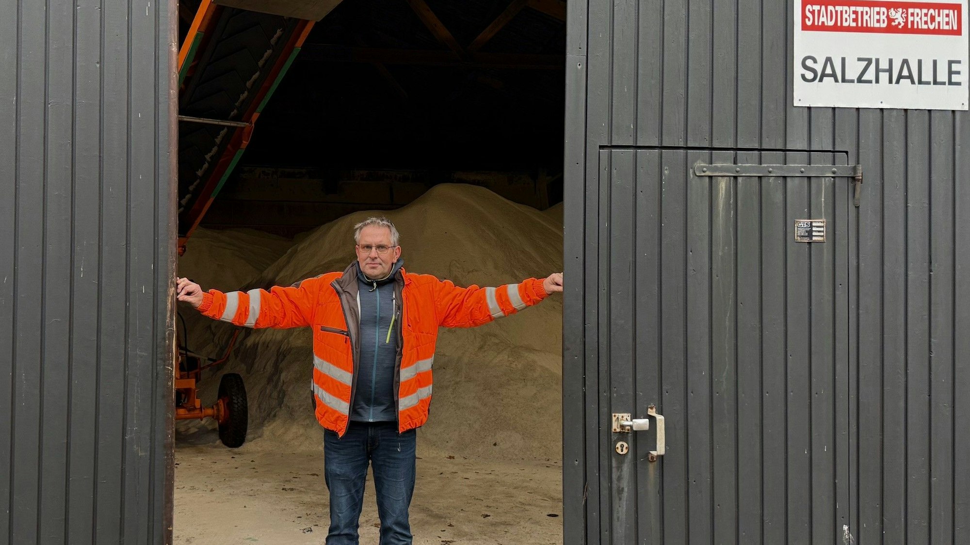 Das Bild zeigt Ralf Harff, der die Tore zur Salzhalle aufschiebt.