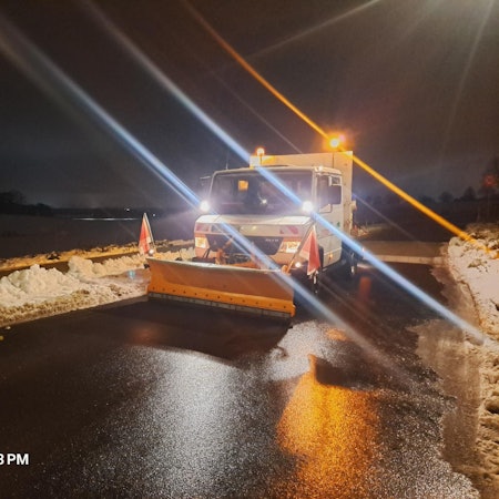 Das Bild zeigt einen Räumwagen der Stadtbetriebe Frechen auf einer Straße mit Schnee.