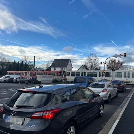 Die Linie 66 quert die Südstraße, die Schranke ist zu, es staut sich an der stark befahrenen Straße.