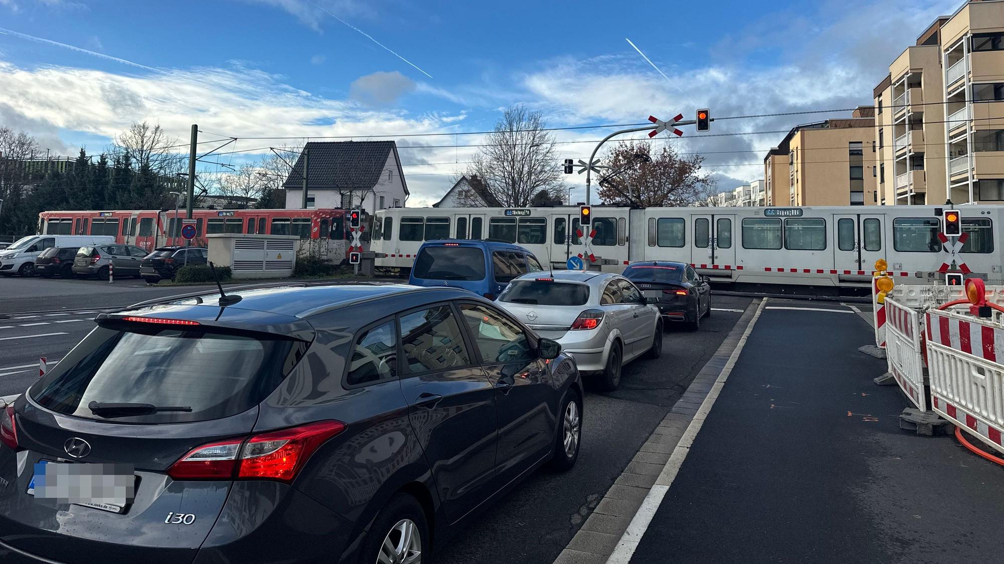 Linie 66 quert die Südstraße, die Schranke ist zu, es staut sich.