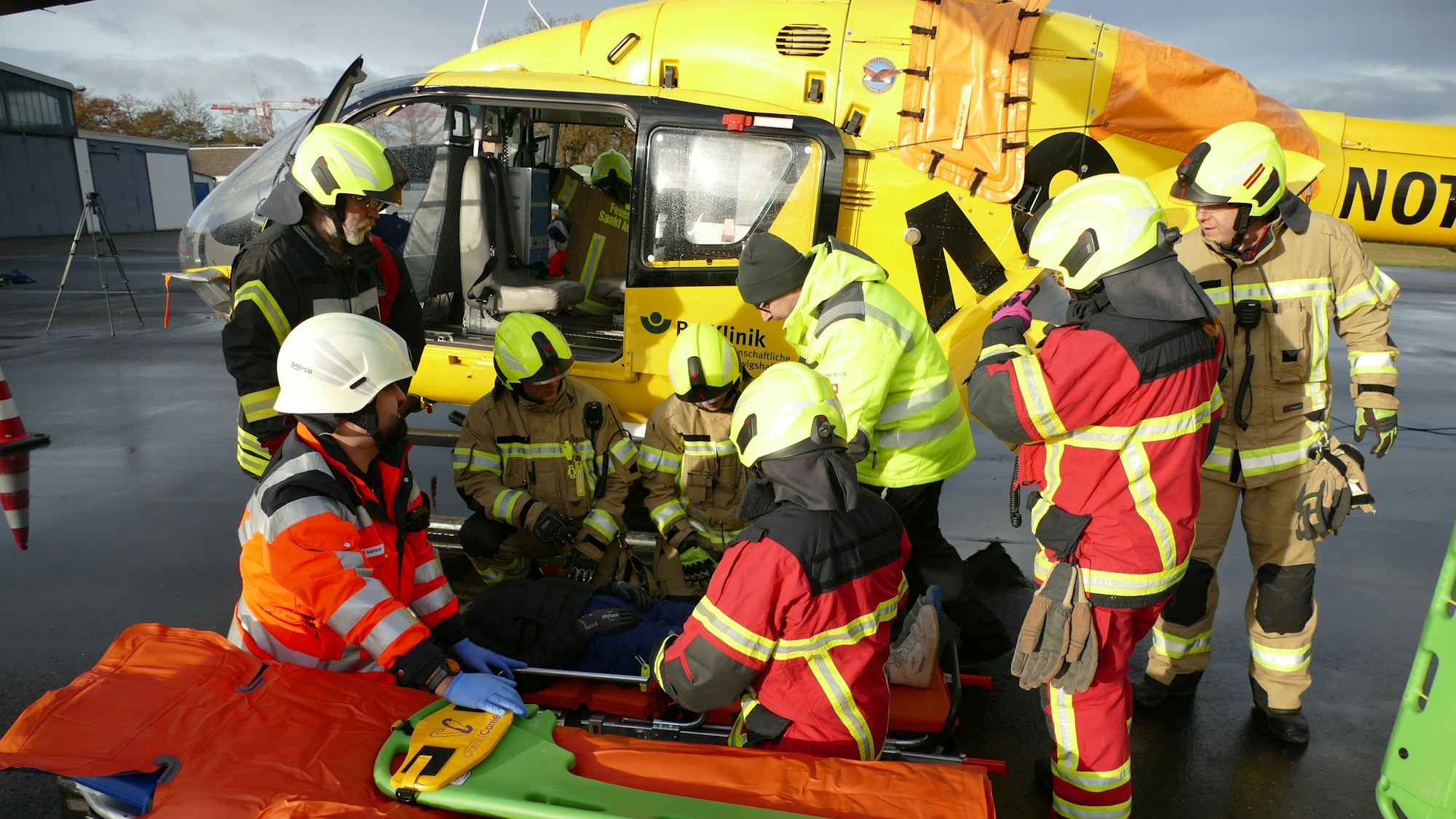 Rettungskräfte stehen am verunglückten Hubschrauber.