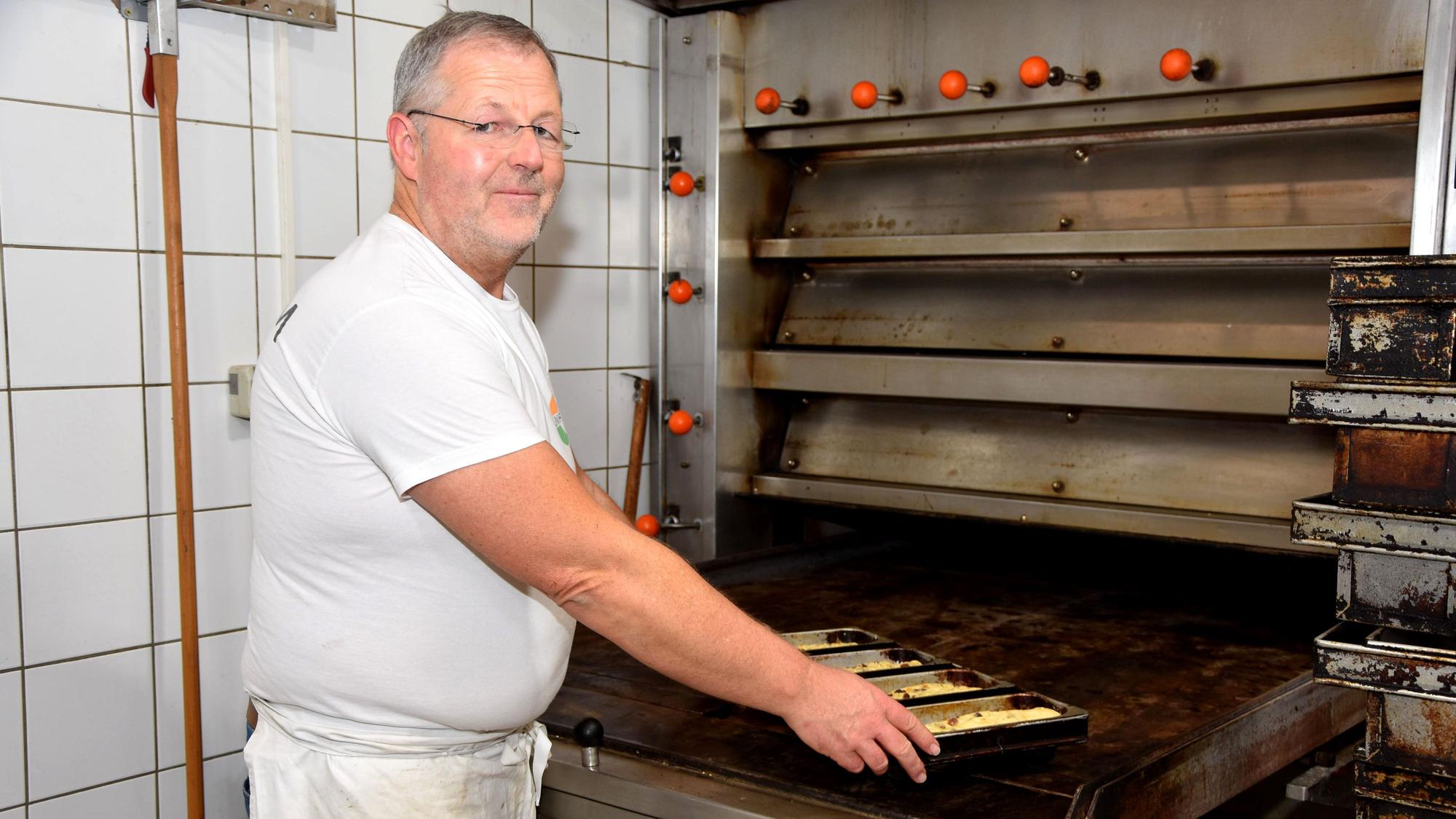 Das Foto zeigt einen Bäcker am Ofen.