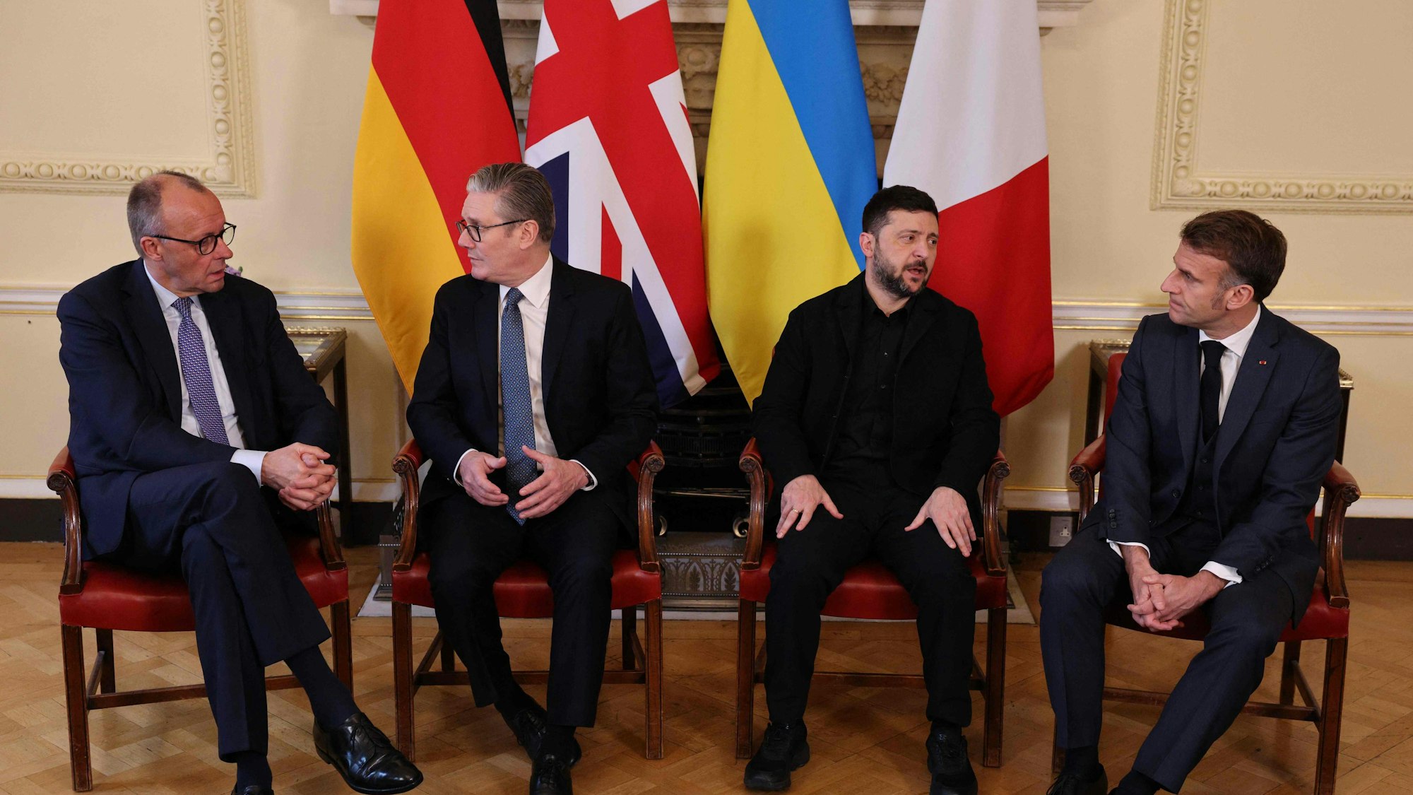 Das Bild zeigt Kanzler Friedrich Merz, den britische Premierminister Keir Starmer, Ukraines Präsident Wolodymyr Selenskyj und Frankreichs Präsident Emmanuel Macron (von links nah rechts), die nach einem Meeting in Downing Street 10 in London zusammensitzen. Foto: Adrian Dennis / Pool / AFP