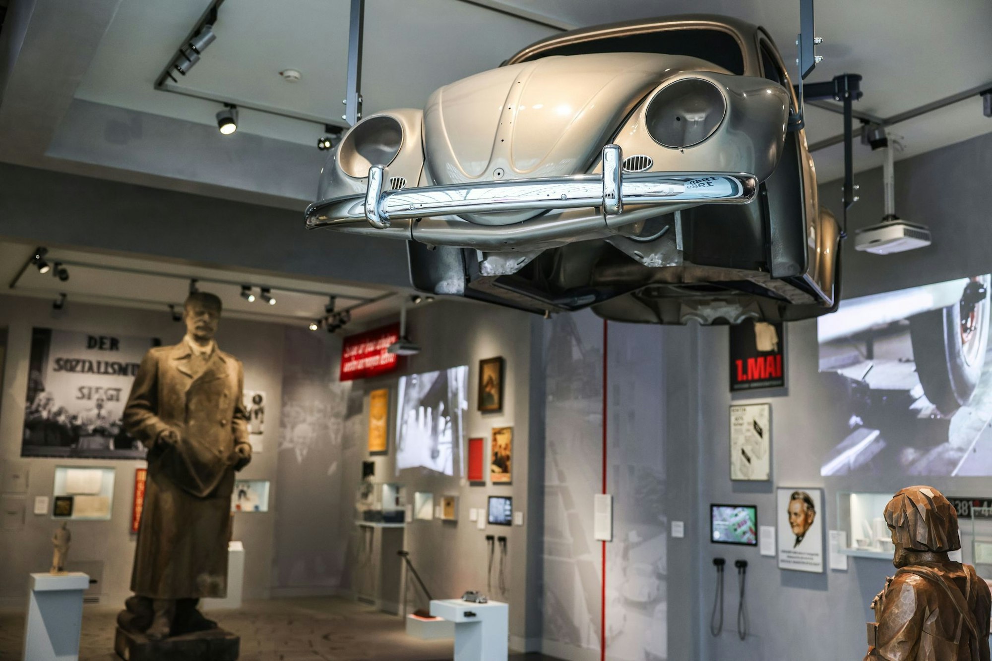 Stalin blickt in Richtung eines VW-Käfers - die Geschichte von BRD und DDR wird parallel erzählt.