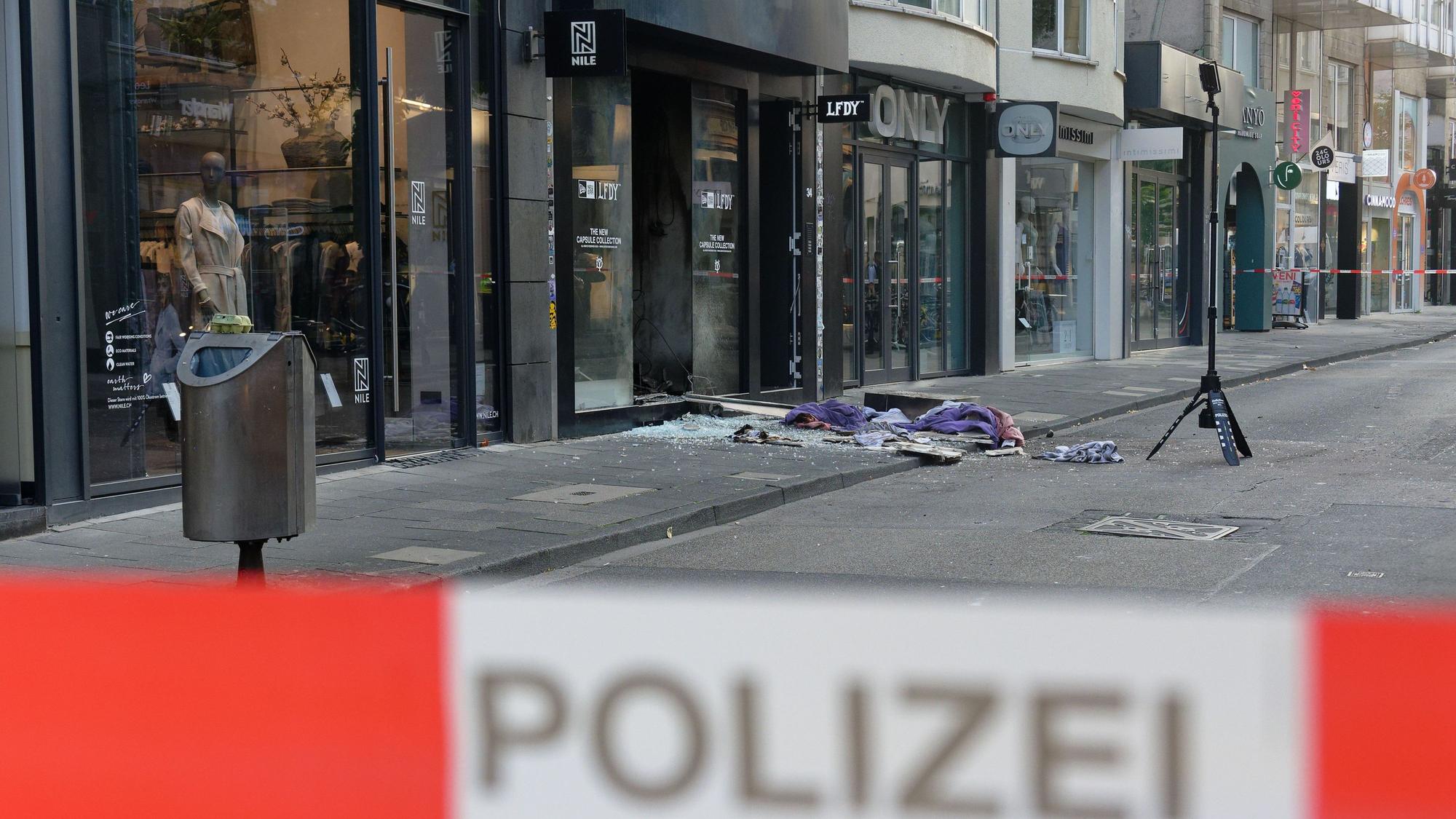 Scherben und Kleidungsstücke liegen nach der Explosion vor dem Geschäft in der Ehrenstraße in Köln.