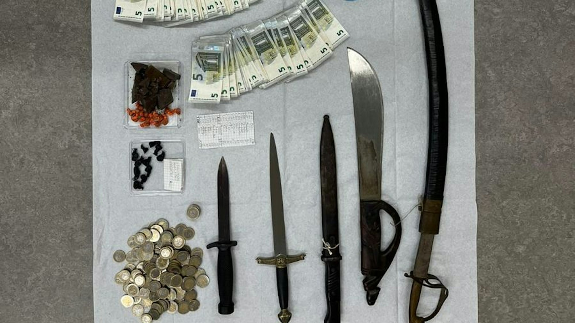 Heroin, Macheten und mehrere tausend Euro Bargeld hat die Polizei in Köln bei einem mutmaßlichen Dealer gefunden.