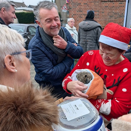 Das Foto zeigt Manuela Hilgert mit Nikolausmütze und Weihnachtspullover und einem in ein Handtuch gewickelten Igel.