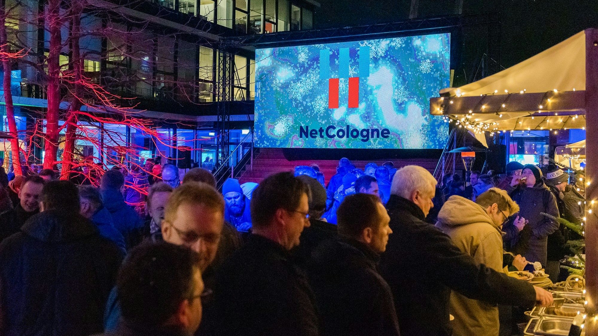 Netcologne-Mitarbeiter bedienen sich an weihnachtlich geschmüchten Essensbuden.