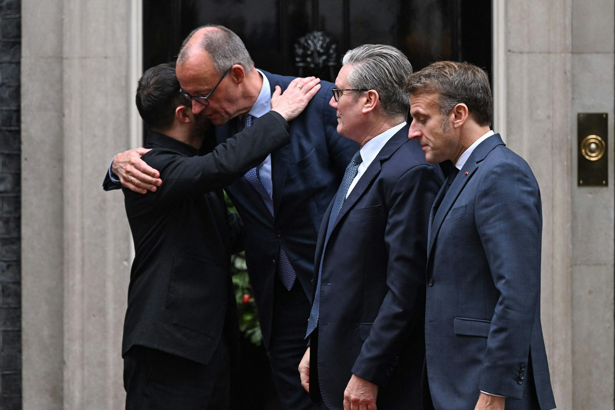 Das Bild zeigt Kanzler Friedrich Merz (links), und Ukraines Präsident Wolodymyr Selenskyj (rechts) bei der Begrüßung vor einem Treffen mit dem britischen Premierminister Keir Starmer (3. von links) und Frankreichs Präsident Emmanuel Macron (ganz rechts) in Downing Street 10 in London. Foto: Chris J Radcliffe / AFP