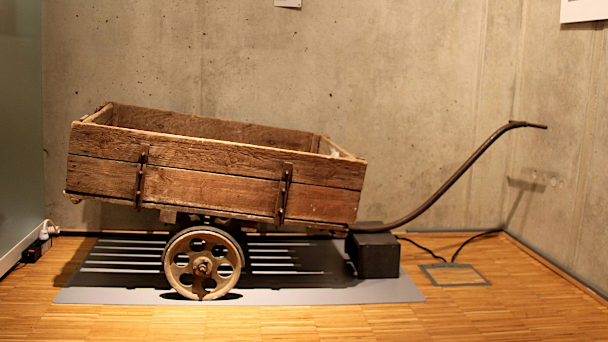 Der Karren steht vor einer Wand.