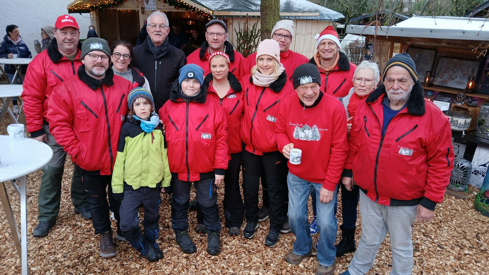 Das Organisationsteam steht nebeneinander und trägt bis auf zwei Ausnahmen rote Jacken.