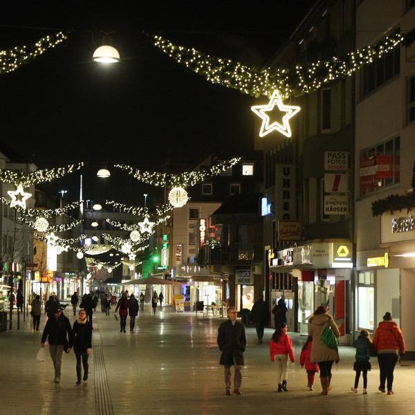 Menschen laufen durch die weihnachtlich geschmückte Bergisch Gladbacher Innenstadt.