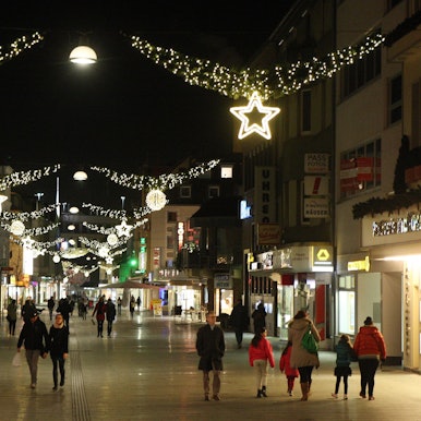 Menschen laufen durch die weihnachtlich geschmückte Bergisch Gladbacher Innenstadt.