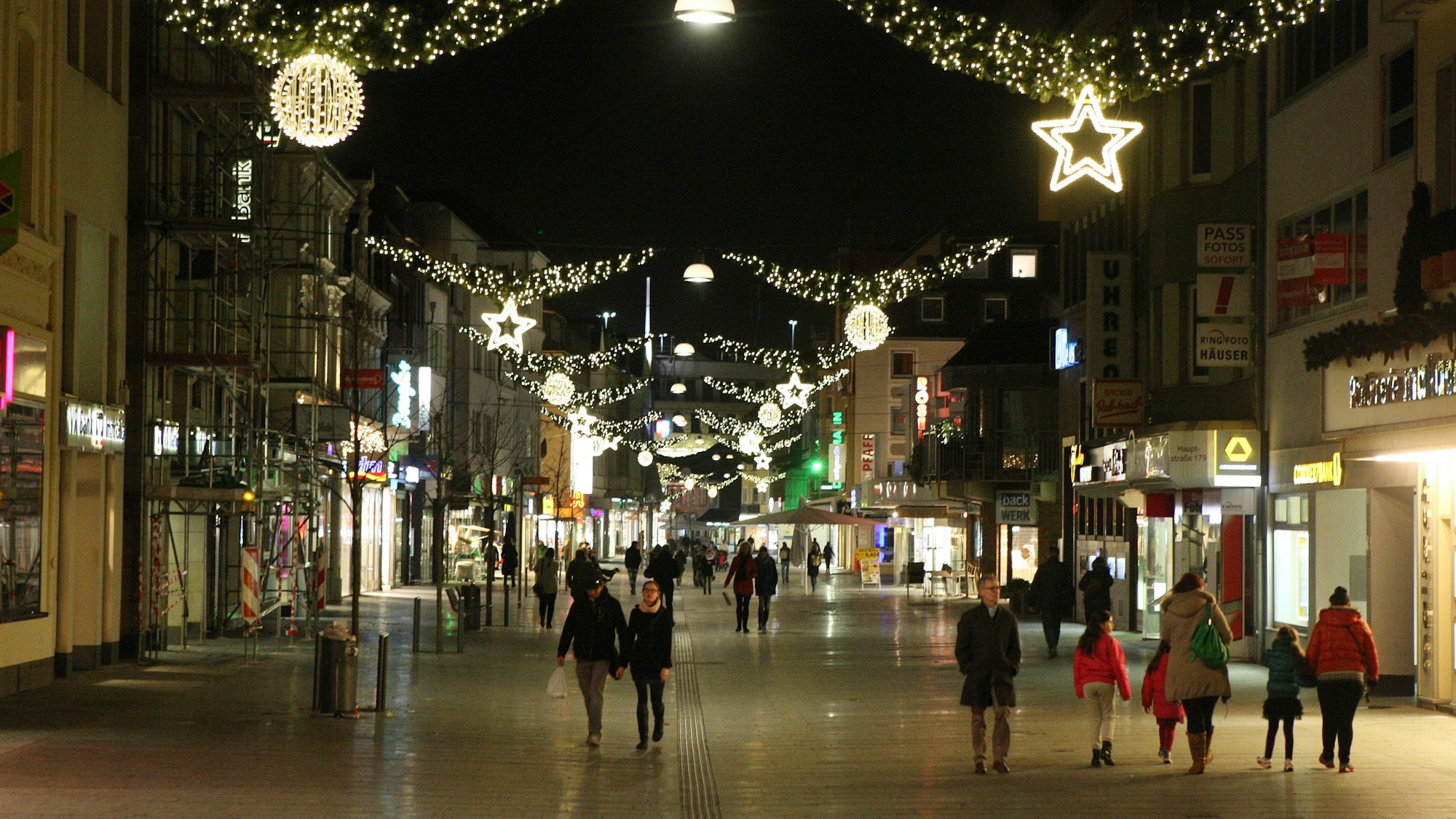 Menschen laufen durch die weihnachtlich geschmückte Bergisch Gladbacher Innenstadt.