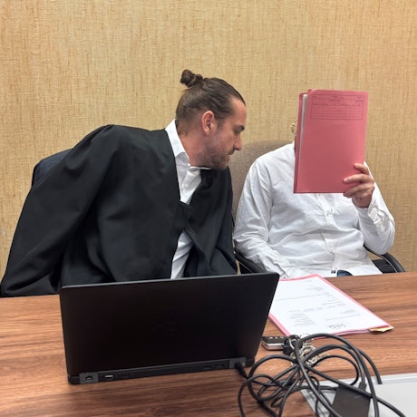 Das Bild zeigt einen Verteidiger und einen Angeklagten im Gericht.