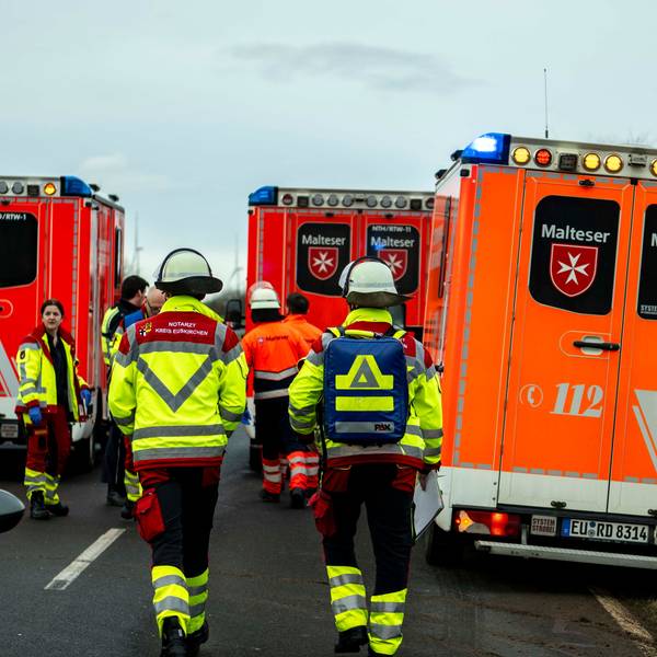 Einsatzkräfte des Rettungsdienstes zwischen Rettungswagen an der Einsatzstelle.