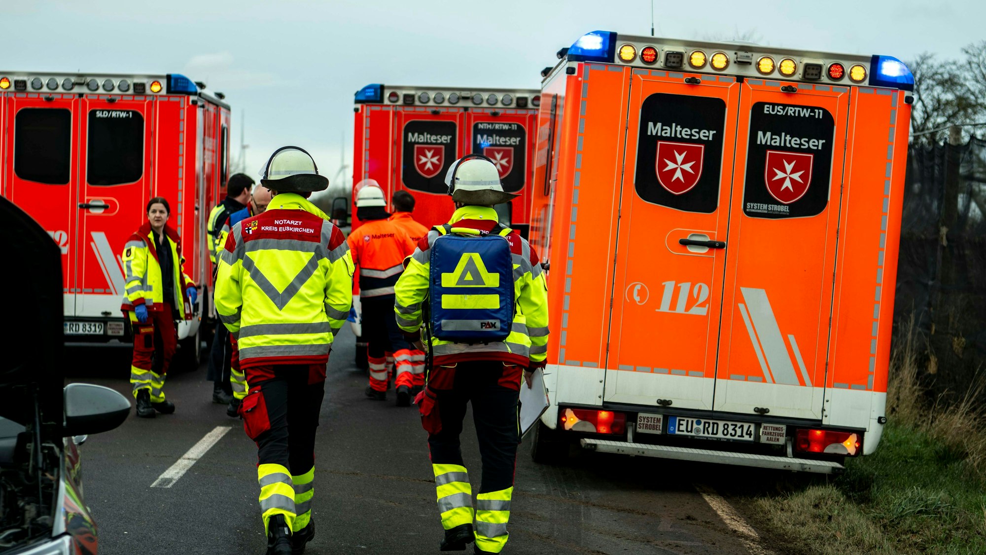 Einsatzkräfte des Rettungsdienstes zwischen Rettungswagen an der Einsatzstelle.