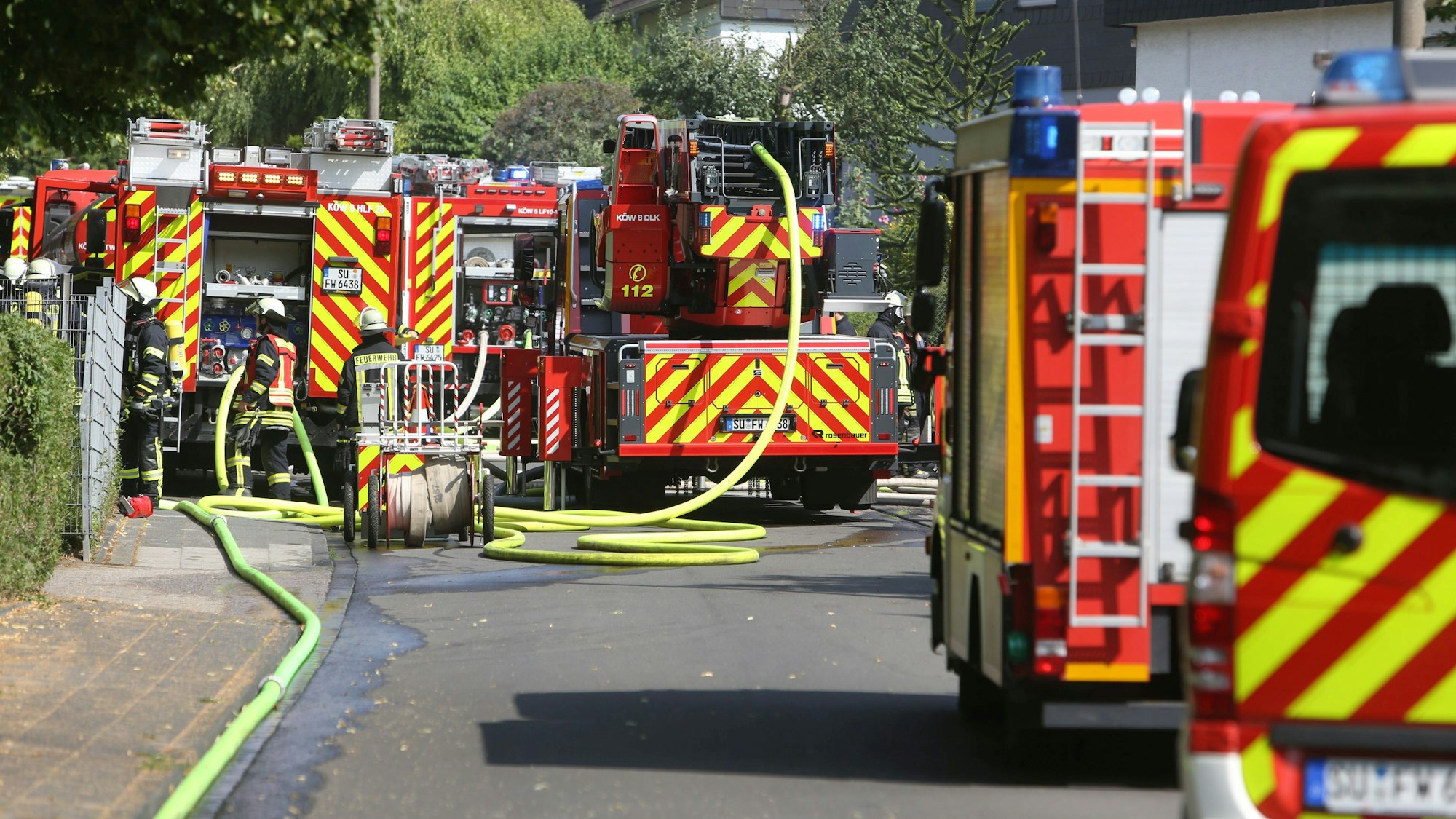 Mehrere Einsatzfahrzeuge der Feuerwehr stehen auf einer Straße.