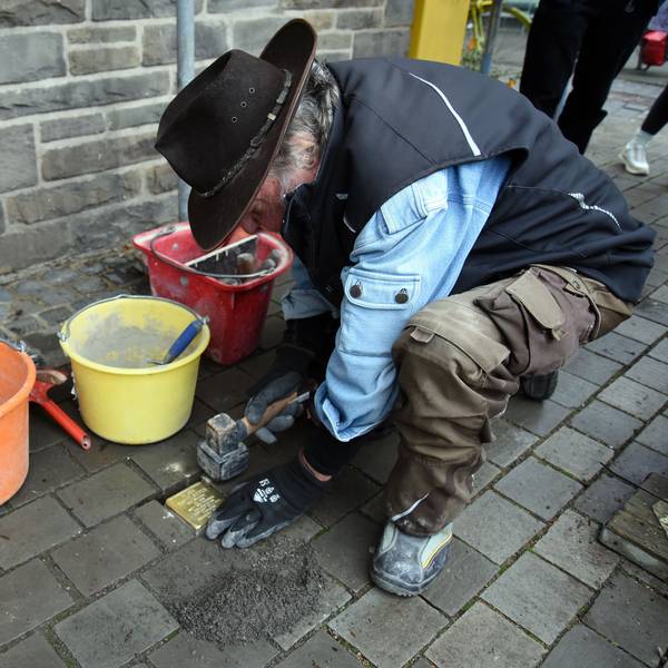Das Foto zeigt den Künstler Gunter Demnig bei der Verlegung eines Stolpersteins