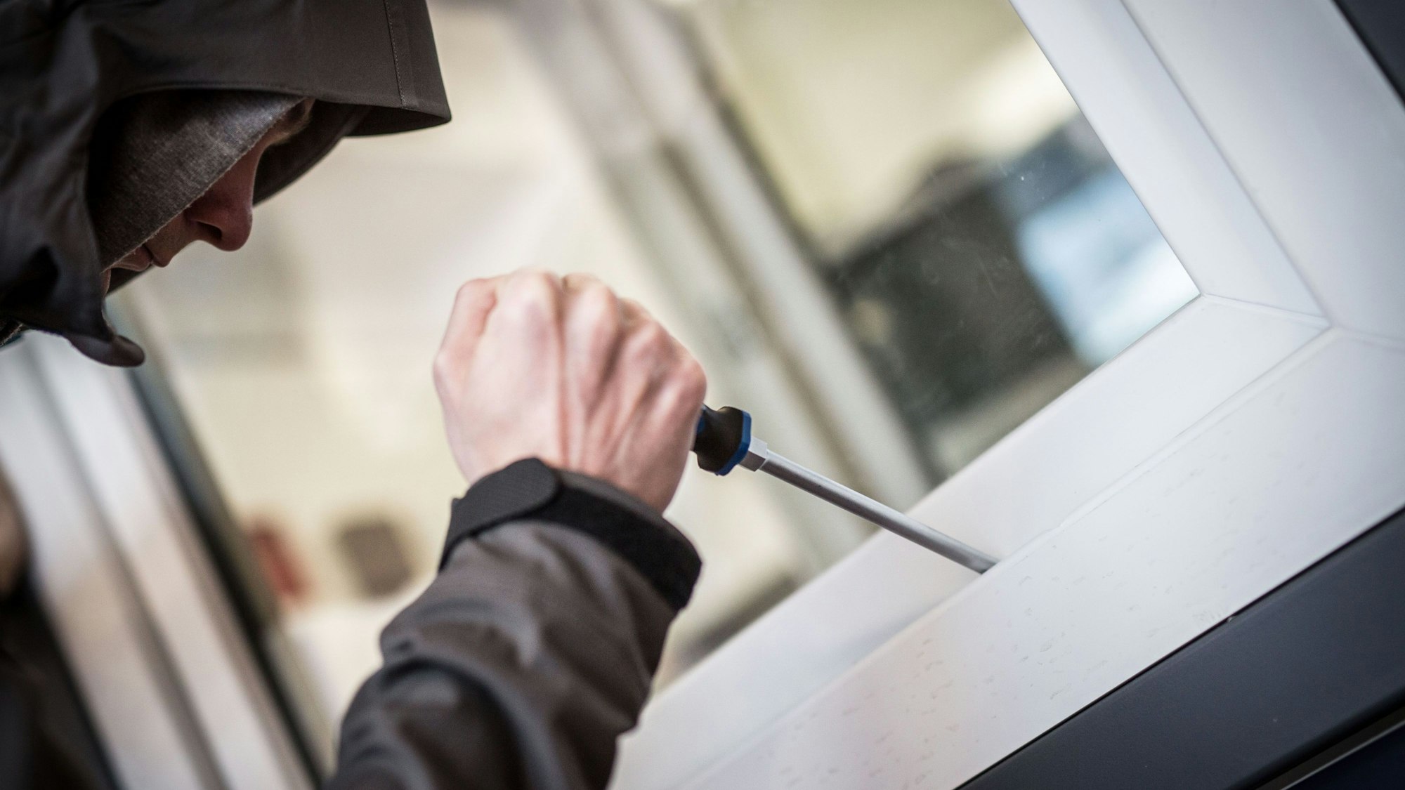 Ein Mann demonstriert in der polizeilichen Beratungsstelle, wie Einbrecher Fenster aufhebeln.