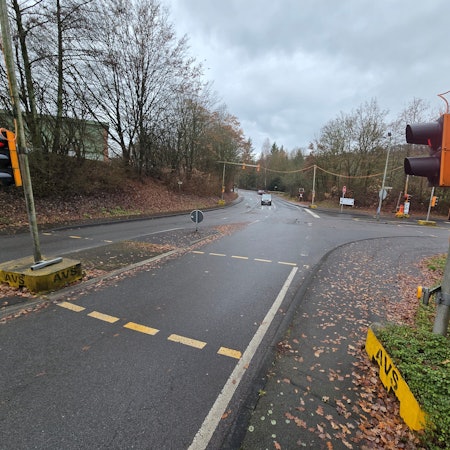 Eine rote Ampel, im Hintergrund eine leere Einmündung.