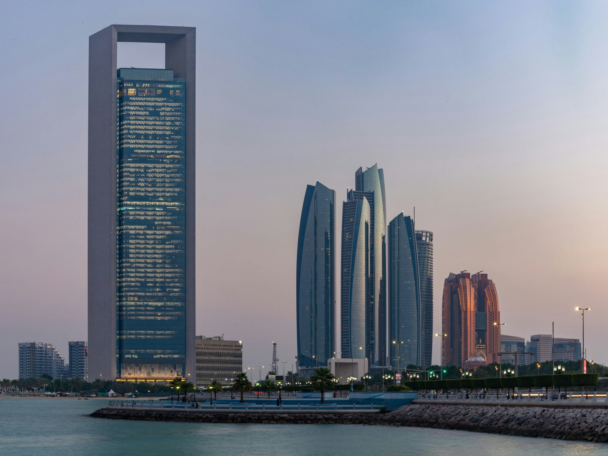 Der 335 Meter hohe Adnoc-Tower in Abu Dhabi in der Dämmerung (links im Bild neben weiteren Wolkenkratzern).