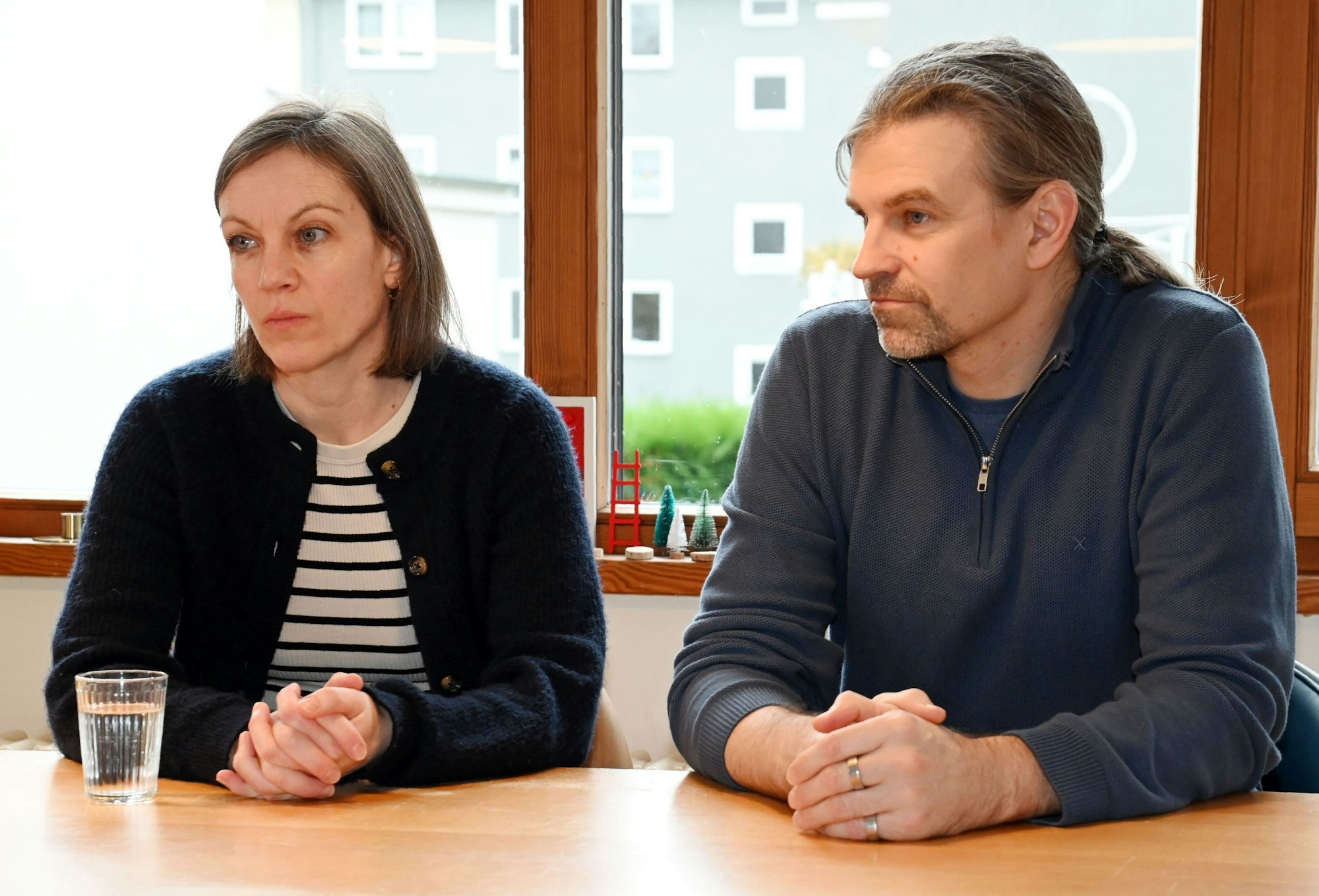 Die Eltern Julischka und Sebastian sitzen am Tisch in einer Gesprächssituation.